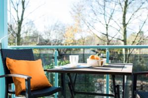 杜塞尔多夫帕克赛德公寓的阳台上的桌子上放着咖啡和橙子