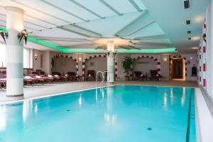 蒂罗尔-泽费尔德奥特施米德希特珀特酒店 的酒店大堂的游泳池,配有桌椅