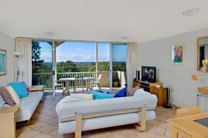佩里吉安比奇阳光海岸地平线酒店的一间带白色沙发的客厅和一个阳台