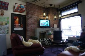 南鱼沼市新福田屋酒店的客厅设有壁炉和电视。