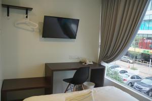 梳邦再也梳邦再也57号 USJ 21酒店的一间卧室配有一张桌子和一台墙上的电视。