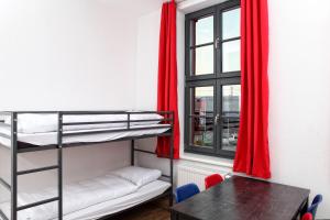 新勃兰登堡Hostel am GÜTERBAHNHOF的客房设有双层床、桌子和窗户。