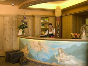 塞埃巴克蒙梅尔湖山区酒店的一名女士在酒吧里用手机画画