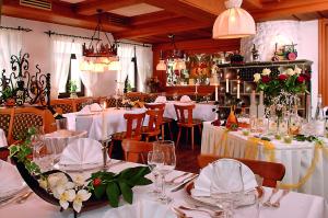 韦因斯塔特拉姆酒店的餐厅设有白色的桌椅和鲜花