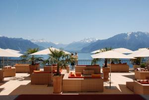 沃韦米兰朵度假酒店及Spa的一个带桌子和遮阳伞的度假村和一个湖泊