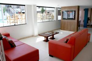 塞古罗港Ancoradouro Hotel - Centro De Porto Seguro的客厅配有两张红色的沙发和一张桌子