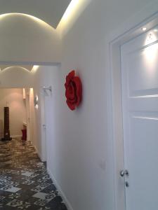 特拉尼Arco' B&B的墙上有一扇门,墙上挂着一朵红花