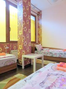 索非亚旅客之家旅馆的一间设有两张床和一张桌子的房间