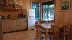 丹马克彩虹之家公寓 的厨房配有桌子和白色冰箱。