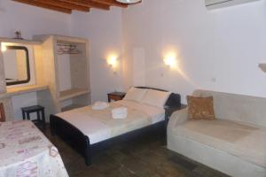 基奥尼亚爱琴海日落公寓的酒店客房,配有床和沙发
