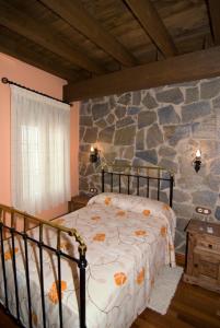 Villar de Plasencia萨尔瓦多林孔德尔比利亚尔酒店的一间卧室设有一张床和石墙