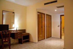 塔拉韦拉·德·拉·雷纳佩拉莱斯酒店的客房设有书桌、椅子和镜子