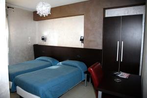 甘吉米拉蒙蒂酒店的一间卧室配有两张床和镜子