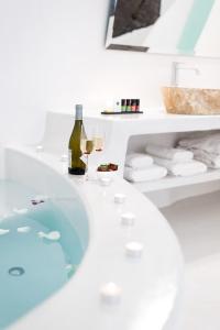伊亚马利基奥套房酒店的带浴缸和葡萄酒的浴室
