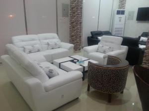 塞卡凯Lara Al Jawf Hotel Apartments的客厅配有白色的沙发和桌子