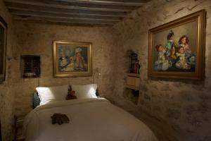 Tāmazrat奥博格德塔梅滋利特酒店的卧室配有一张床,墙上挂有绘画作品