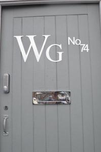 麦克尔斯菲尔德Wg Apartment的一面有标志的金属门