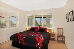 卢拉圣拉菲尔乡村民宿的一间卧室配有一张带黑色和红色毯子的床