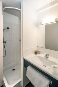 圣弗卢尔Brit Hotel Essentiel Saint-Flour的一间带水槽、淋浴和镜子的浴室