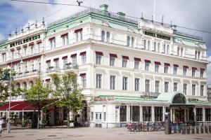 哥德堡埃格斯酒店的一座白色的大建筑,前面有自行车停放
