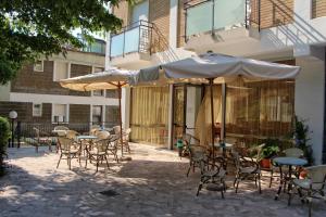 加比切马莱Sporting hotel的一个带桌椅和遮阳伞的户外庭院。
