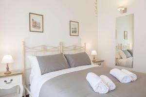 罗马唐娜玛格丽特​​罗马套房酒店的卧室配有带毛巾的大型白色床