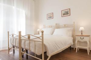 罗马唐娜玛格丽特​​罗马套房酒店的卧室配有白色的床和椅子