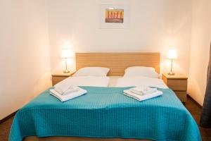布拉迪斯拉发佩蒂特迪潘登思旅馆的一间卧室配有一张床,上面有两条毛巾