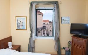 斯普利特珀里斯提酒店的一间卧室设有窗户、窗帘和电视
