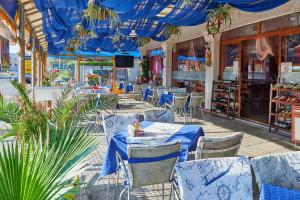 帕莫瑞Petar and Pavel Hotel & Relax Center的餐厅拥有蓝色的天花板和桌椅