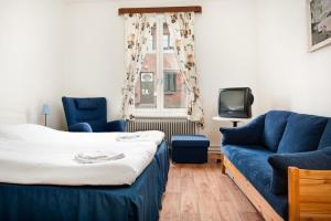 厄斯特松德斯维客栈酒店的一间卧室配有一张床、一张沙发和一台电视。