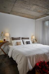 Janeiro de CimaCasa De Janeiro的卧室配有一张白色大床和两盏灯。