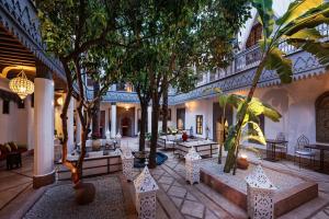马拉喀什里亚德花园赫尼亚住宿加早餐旅馆的一座建筑中带树木和沙发的庭院