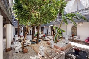 马拉喀什里亚德花园赫尼亚住宿加早餐旅馆的一座庭院,里面种有树木和长凳
