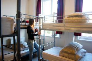 伦敦多佛城堡旅馆 的一位妇女站在带双层床的房间