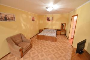 尼古拉耶夫Apartment Style on Sobornaya Street的配有床、椅子和电视的房间
