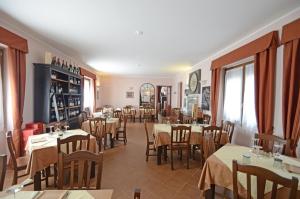 PonzoneRelais Ristorante Sanfront的一间在房间内配有桌椅的餐厅