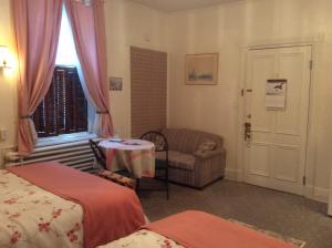 魁北克市德默斯之家宾馆的客房设有两张床、一张桌子和一扇窗户。
