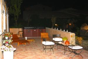 雷苏塔诺摩纳哥迪梅佐农庄酒店的庭院在晚上配有桌椅和长凳