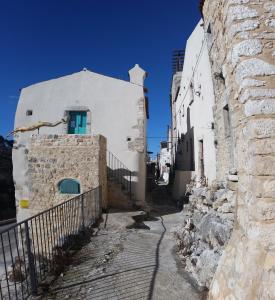维科德尔加尔加诺Case Vacanza Al Borgo Antico的一条有白色建筑的小巷,有蓝色的门
