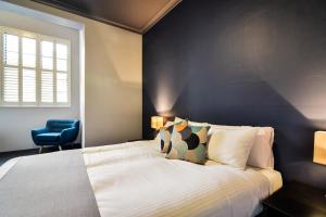 奥兰治卡诺博拉斯酒店的一间卧室设有一张床和蓝色的墙壁