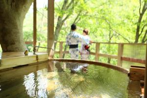高山Fukeikan 風景館的两人站在水池旁