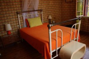 干尼亚Kyra Vintage House的一间卧室配有一张带橙色棉被的床