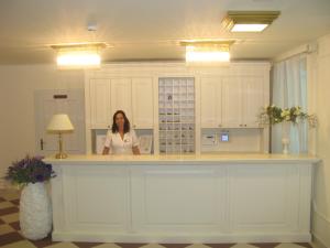 大洛希尼Hotel Villa Elisabeth - Veli Lošinj Health Resort的站在房间柜台上的女人