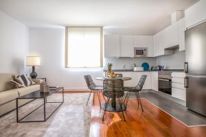 马德里奥古斯托慢慢套房公寓的厨房以及带桌椅的起居室。