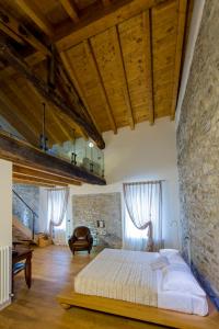 Oggiono普雷西迪奥二世酒店的一间卧室设有一张床和石墙