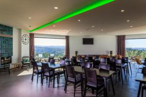 圣特奥托纽谜 - 自然与水酒店 的用餐室配有桌椅和绿灯