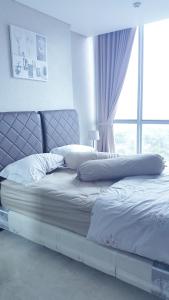 雅加达温莎招牌公寓的卧室内的一张床铺,设有大窗户