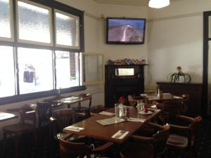 悉尼梅坎提勒酒店的用餐室设有桌椅和窗户。
