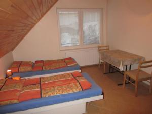利普托斯基米库拉斯Apartments Centrum的带三张床、一张桌子和椅子的房间